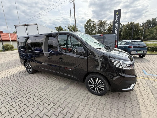 Widok boku auta Renault Traffic należącego do cezarbus.com. Firma zajmuje się przewozem osób busami do Niemiec, z adresu na adres.